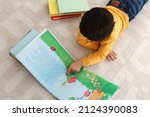 Cute little boy reading book on ...