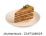 Slice of delicious layered honey cake with mint isolated on white