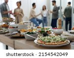 Small photo of Brunch table setting with different delicious food and blurred view of people on background