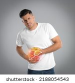 Small photo of Man suffering from liver pain on grey background