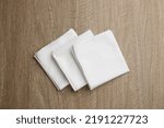 Stylish white handkerchiefs on wooden table, flat lay