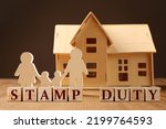Stamp duty. Family and house wooden figures on table