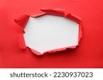 Hole in red paper on white background