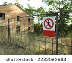 Sign Access forbidden all unauthorized persons with text in Italian attached to fence