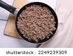 Fried minced meat in pan on white wooden table, top view