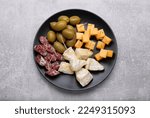 Toothpick appetizers. Pieces of cheese, sausage and olives on light grey table, top view