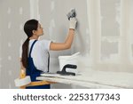 Worker plastering wall with...