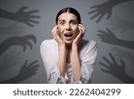 Small photo of Paranoid delusion. Scared woman screaming on grey background. Shadows of hands reaching for her symbolizing fear and anxiety