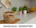 Traditional Easter cake with dried fruits on table in kitchen, space for text