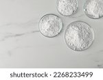 Small photo of Many petri dishes with calcium carbonate powder on white marble table, flat lay. Space for text