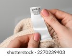 Woman holding clothing label on ...