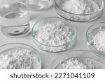 Small photo of Many petri dishes with calcium carbonate powder on white background