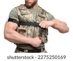Small photo of Soldier in military uniform applying medical tourniquet on arm against white background, closeup