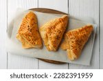 Fresh delicious puff pastry on white wooden table, top view