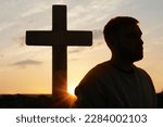 Small photo of Atheism. Silhouette of man turned away from Christian cross outdoors at sunrise