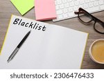 Small photo of Word Blacklist written in notepad, computer keyboard and paper notes on wooden table, flat lay