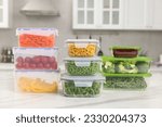 Glass and plastic containers with different fresh products on white marble table in kitchen. Food storage