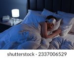 Woman with mask sleeping in bed at night