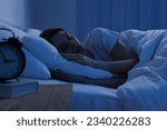 Handsome man sleeping in bed at ...
