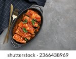 Small photo of Delicious stuffed cabbage rolls cooked with tomato sauce on grey table, flat lay. Space for text
