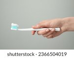 Woman holding toothbrush with...