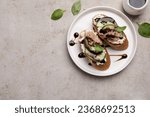 Delicious bruschettas with balsamic vinegar and toppings on light textured table, flat lay. Space for text
