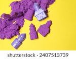 Small photo of Castle figures made of kinetic sand and plastic toys on yellow background, flat lay. Space for text