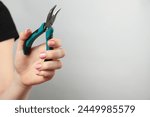 Woman with bent nose pliers on...