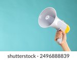 Woman holding megaphone speaker on blue background, closeup. Space for text