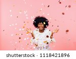 Celebrating happiness, young woman with big smile throwing confetti	
