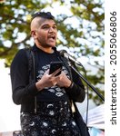 Small photo of SACRAMENTO, CA, U.S.A. - OCTOBER 9, 2021: Josie Robo, a spoken word artist, reads their poem "Land of Imaginary Beasts" as part of National Trans Visibility March Day.