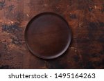 Empty plate and linen napkin on brown wooden background Copy space Top view - Image