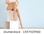 Woman with beautiful legs after depilation on color background