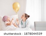 Small photo of Doctor with golden balloon and little girl undergoing course of chemotherapy in clinic. Childhood cancer awareness concept