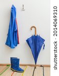Small photo of Raincoat, umbrella and gumboots in hallway