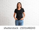 Young woman in blank t-shirt on white brick background