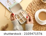 Female hands with beautiful manicure holding jewelry box on color background