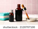 Bottles with iodine, pipette, cotton pads and first aid kit on tile background