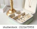Box with different stylish jewelry on white table, closeup