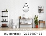Stylish interior of restroom with toilet bowl, modern sink and holder with toilet paper rolls