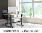 Standing desk with modern computer and chair in office
