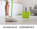 Young man mopping floor in...