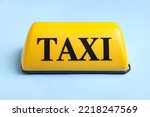 Yellow taxi roof sign on blue background