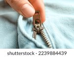 Woman zipping denim clothes, closeup