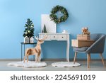 Interior of living room with Christmas wreath, fir trees and table