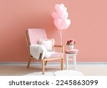Interior of stylish living room with armchair and pink balloons for Valentine