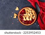 Plate with sweet strawberry pie for Valentine's day on dark background
