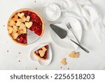 Stand and heart-shaped plates with sweet strawberry pie and cookie hearts for Valentine's day on white background