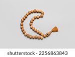 Small photo of Prayer beads in shape of crescent for Ramadan on grey background