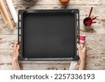 Woman with napkin and baking tray on wooden background